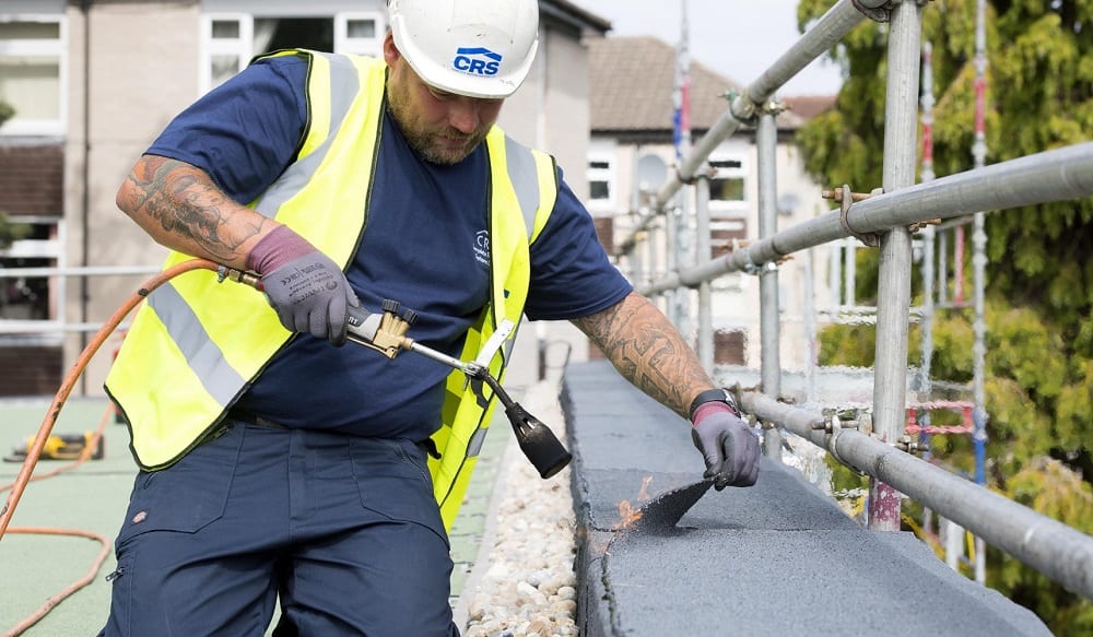 Roofer installing built-up felt