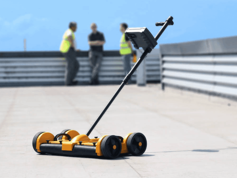 Tramex Dec Scanner, full unit in position on a flat roof with operatives in the background