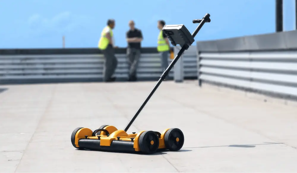 Tramex moisture mapping tool being used on a flat commercial roof to detect and map moisture within the roofing system.